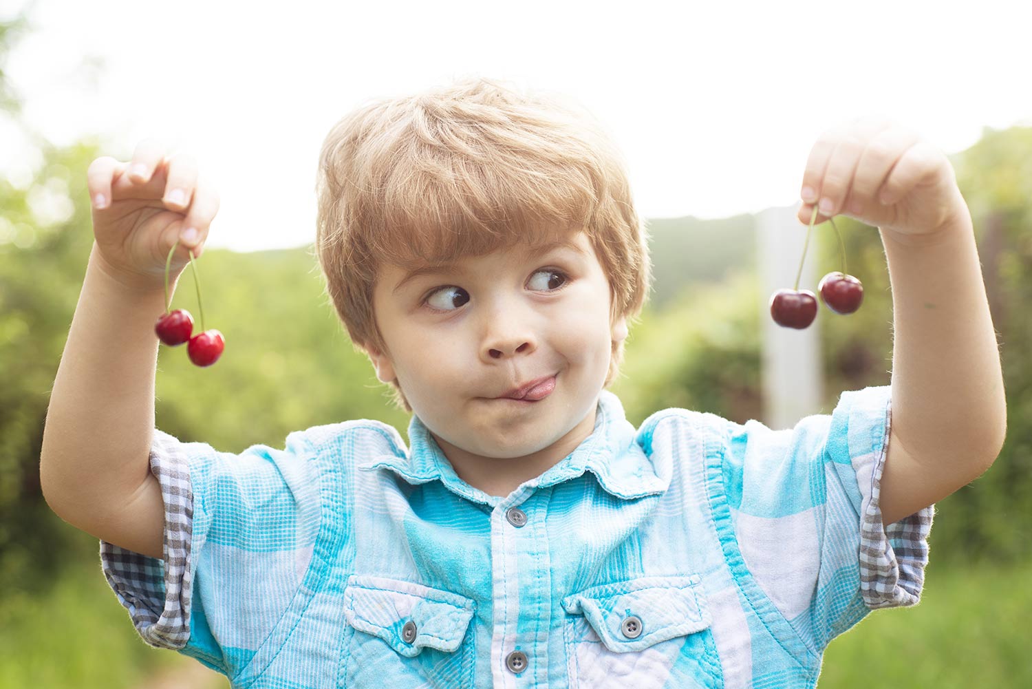 Kid Playing with cherries in both hands